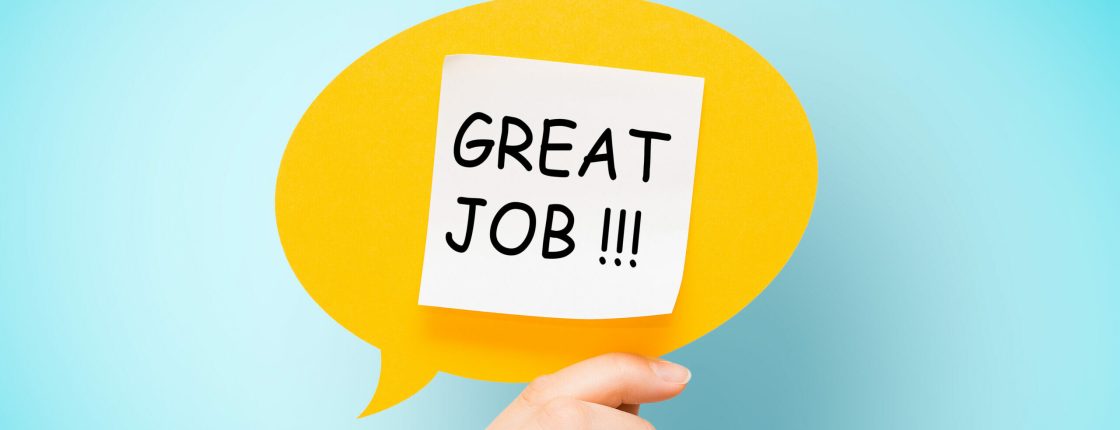 Adhesive note on yellow speech bubble with "great job" words on blue background.