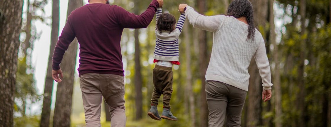 Married couple swinging their young child with special needs, considering a special needs trust for their child in Wisconsin at Turke & Steil LLP in Madison, WI